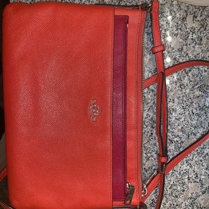 Orange Coach crossbody bag with red purse insert